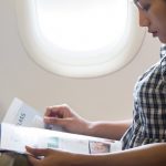 Women reading paper on flight