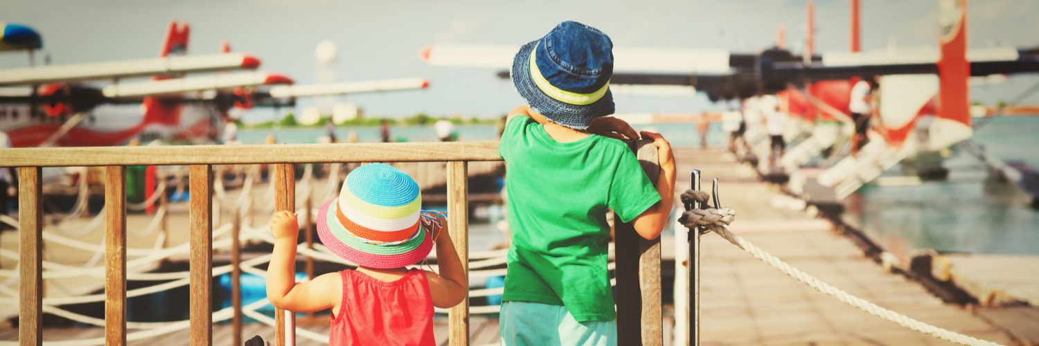 kids looking at planes at an airport