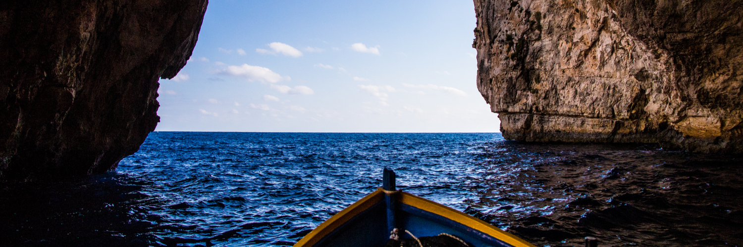 boat leaving blue grotto cave in malta