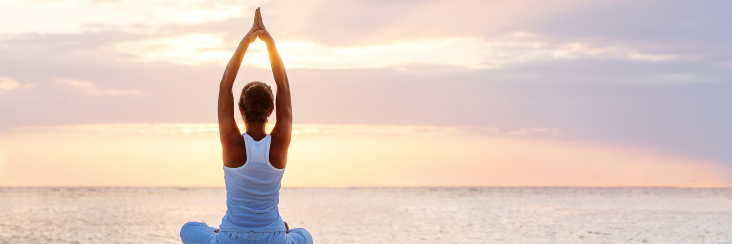 practicing yoga on a beach